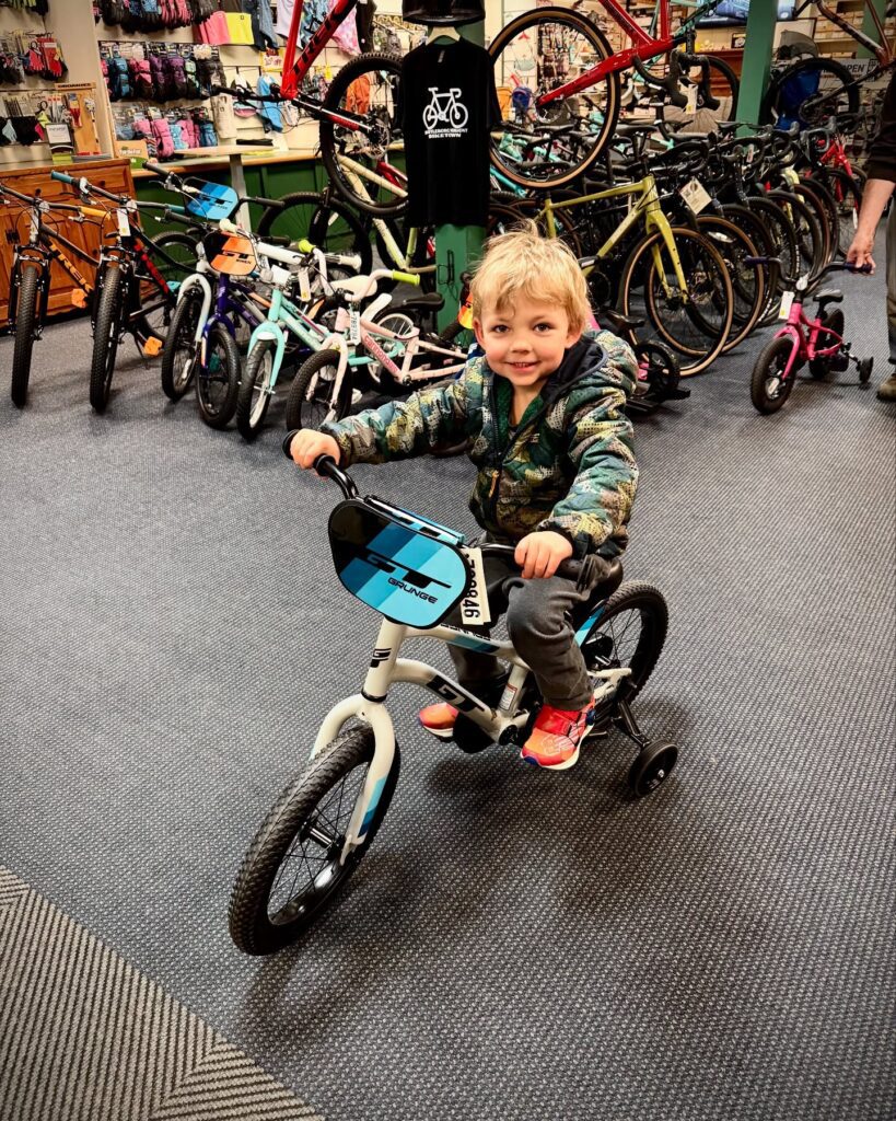 child testing out a new bike at burrows sports in brattleboro