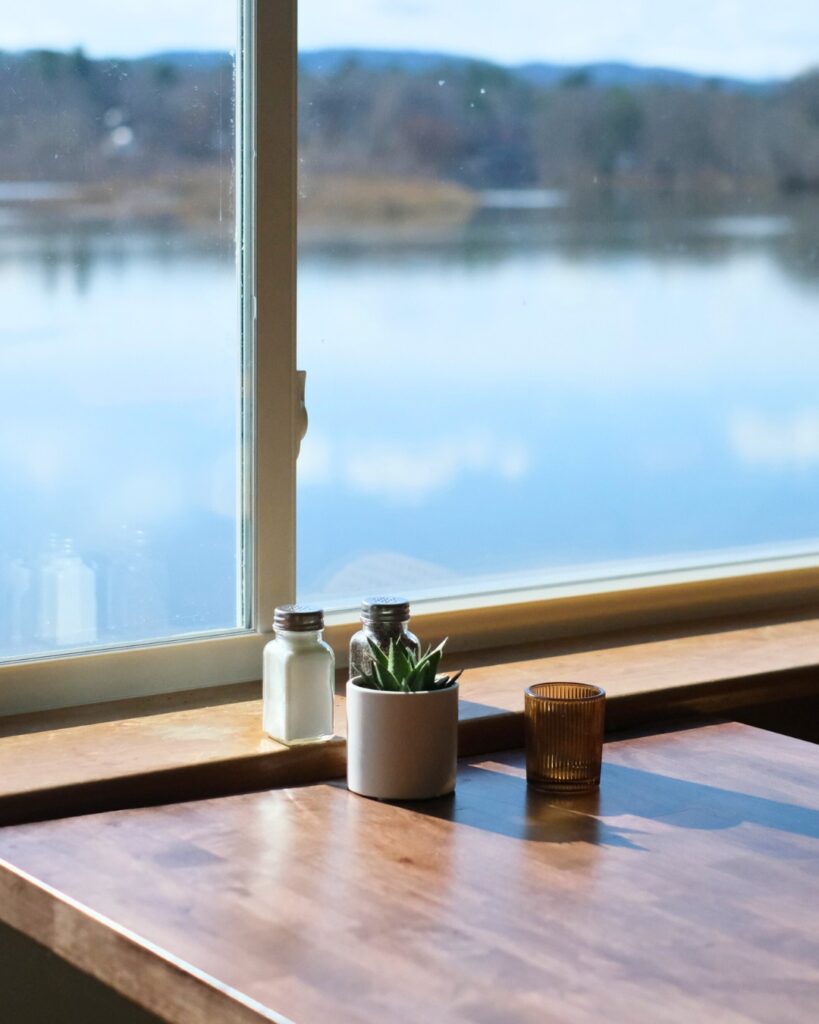 indoor table with view of the west river at the marina restaurant in brattleboro